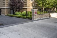 a city street filled with a stone and brick building next to a sidewalk and trees