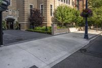 a city street filled with a stone and brick building next to a sidewalk and trees