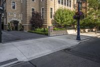 a city street filled with a stone and brick building next to a sidewalk and trees