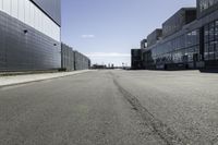 empty city street with buildings on either side of it and a blue sky above them