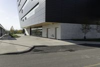 black and white building next to street, with yellow line near the curb with cars