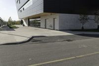 black and white building next to street, with yellow line near the curb with cars