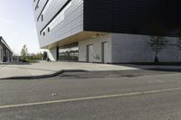 black and white building next to street, with yellow line near the curb with cars