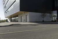 black and white building next to street, with yellow line near the curb with cars