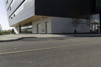 black and white building next to street, with yellow line near the curb with cars