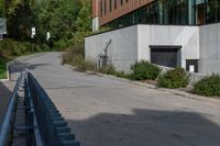 an empty concrete path with a metal fence and building in the background from the bottom