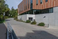 an empty concrete path with a metal fence and building in the background from the bottom