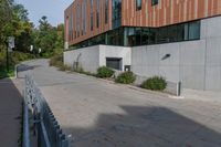 an empty concrete path with a metal fence and building in the background from the bottom