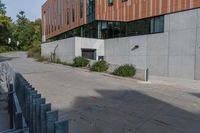 an empty concrete path with a metal fence and building in the background from the bottom