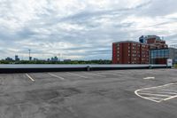 an empty parking lot with buildings in the background and no one standing inside of it