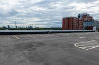 an empty parking lot with buildings in the background and no one standing inside of it