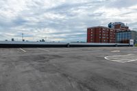 an empty parking lot with buildings in the background and no one standing inside of it