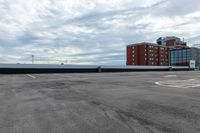 an empty parking lot with buildings in the background and no one standing inside of it