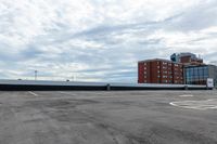 an empty parking lot with buildings in the background and no one standing inside of it