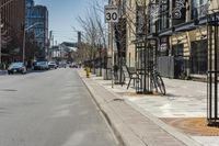 a bicycle parked at the curb on an empty street during the day in a city