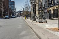 a bicycle parked at the curb on an empty street during the day in a city