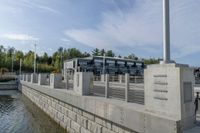 a dock with a building and trees behind it at the dock, with water and benches to sit beside it