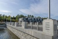 a dock with a building and trees behind it at the dock, with water and benches to sit beside it