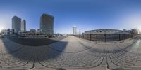 a fish eye photo with some buildings and buildings in the background with a bike parked on the curb