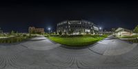 a photo taken with a fish - eye lens that is turned upside down to show a large building and grass