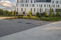 a city street surrounded by grass and tall buildings at the end of a street there is a paved pathway in front of the building