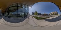 a 360 - view photograph of a large building with a circular mirror view in a courtyard