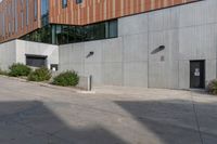 a red fire hydrant is on the pavement in front of a large grey building