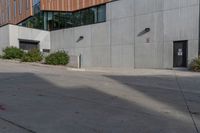 a red fire hydrant is on the pavement in front of a large grey building