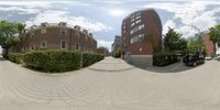 a street view of two cars and buildings in the background, there are some people walking on the sidewalk