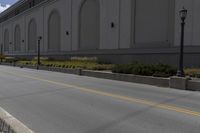 a person on a skateboard in the middle of a road beside a building with a sign