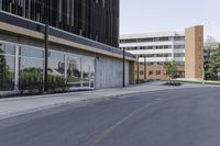 a road next to an office building with glass doors and windows on both sides of it