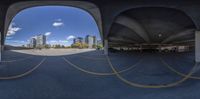 the city is seen through a fisheye lens with the building in the distance, and a car is parked on the parking lot below