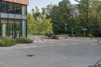 the view of an open air parking lot near a tall building with windows and a fence