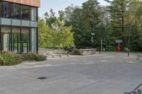 the view of an open air parking lot near a tall building with windows and a fence