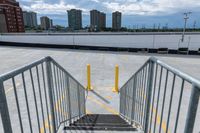 the gate to a parking lot in front of buildings is open with railings up