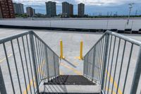 the gate to a parking lot in front of buildings is open with railings up