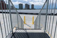 the gate to a parking lot in front of buildings is open with railings up