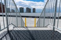 the gate to a parking lot in front of buildings is open with railings up