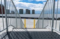 the gate to a parking lot in front of buildings is open with railings up