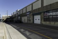 an empty street next to a large warehouse building that has a sign advertising the store