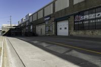 an empty street next to a large warehouse building that has a sign advertising the store