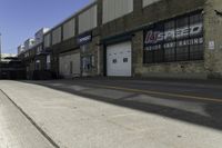 an empty street next to a large warehouse building that has a sign advertising the store