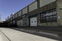 an empty street next to a large warehouse building that has a sign advertising the store