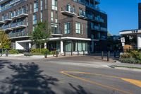 the black apartment building with balcony has white railings and glass windows on a sunny day