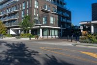 the black apartment building with balcony has white railings and glass windows on a sunny day