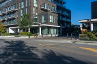 the black apartment building with balcony has white railings and glass windows on a sunny day