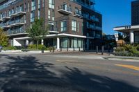 the black apartment building with balcony has white railings and glass windows on a sunny day