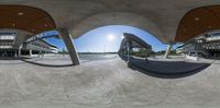 a large circular panorama view of an empty parking lot and a skateboarder going around it