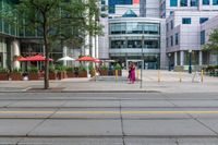 people walk in front of some office buildings while others walk by on the sidewalk and street