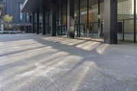 a building with large windows next to a sidewalk with parking meters in front of it